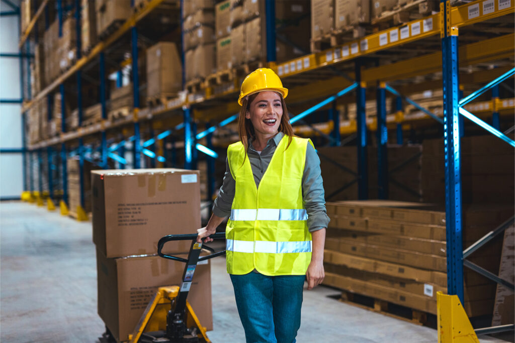 a smiling worker using one of the best pallet trucks in a warehouse