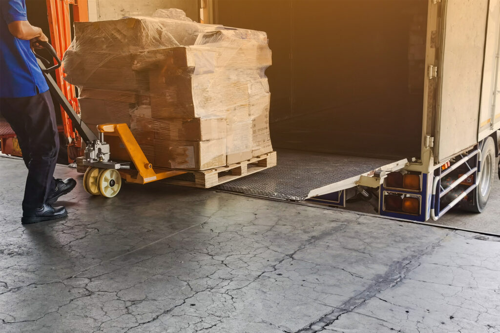 a worker unloading a van using a pallet truck