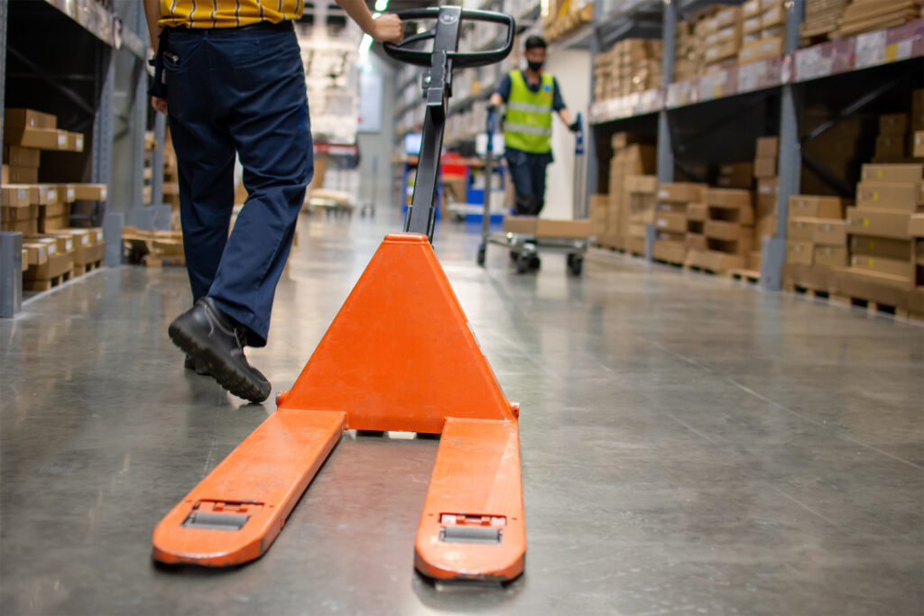 an example of what is a pallet truck - a manual hand pallet jack being used in a warehouse