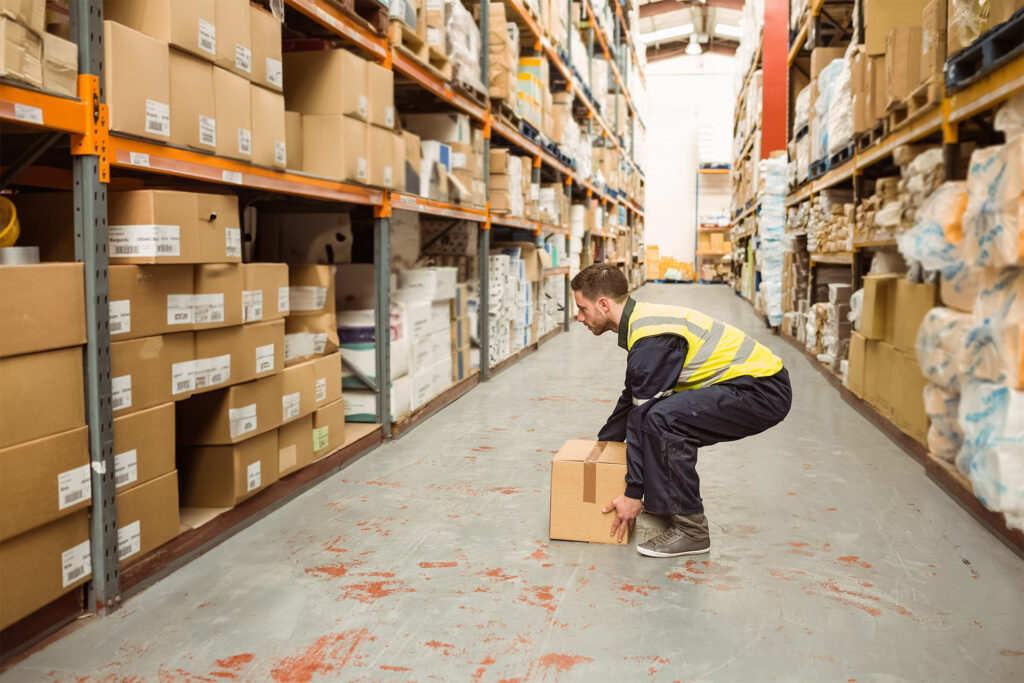 an example of what is manual handling - a worker lifting a box in a distribution centre