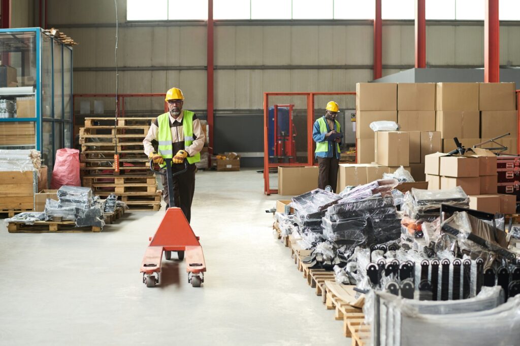 a warehouse worker demonstrating how to use a pallet truck safely