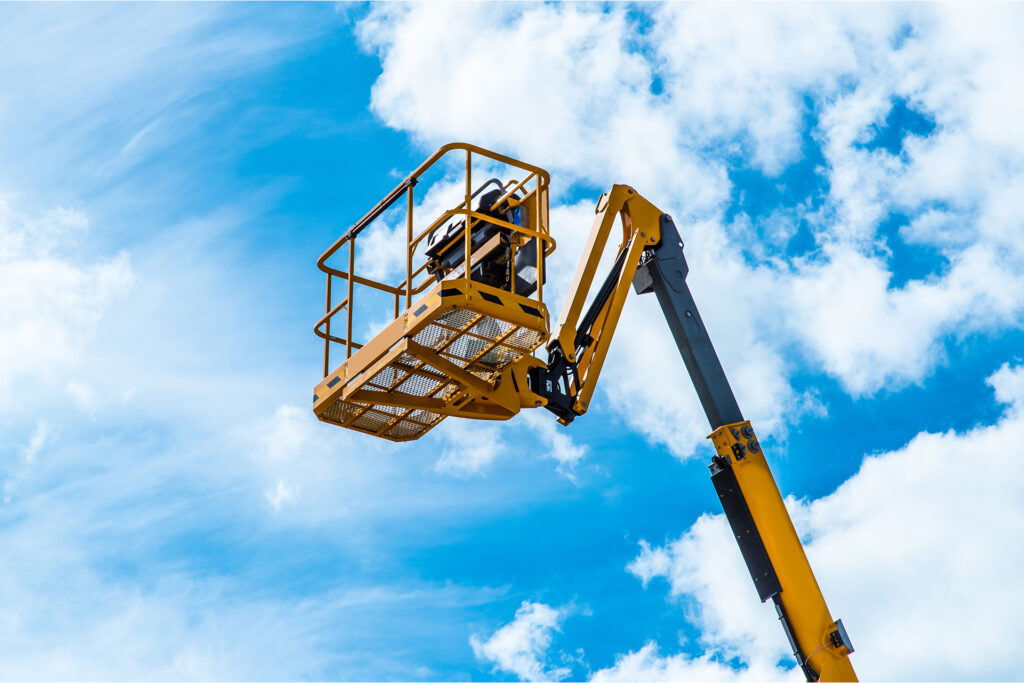 an MEWP held up against the backdrop of a blue cloudy sky